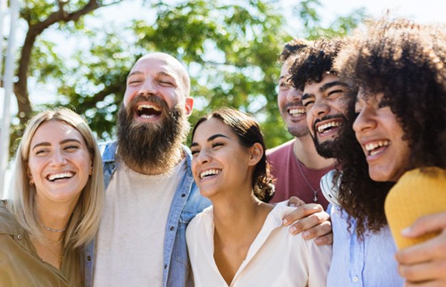 Patient in Sumner smiling with friends after cosmetic dental bonding